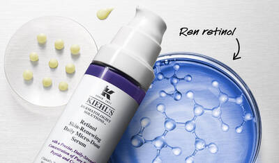 A close-up of Kiehl's Retinol Skin-Renewing Daily Micro-Dose Serum bottle next to a petri dish showcasing round capsules and molecular structures, emphasizing the product's pure retinol content.