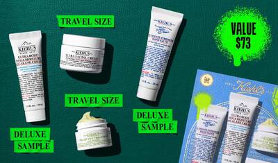 En grafik, sat mod en mørkegrøn tekstureret baggrund, viser fire Kiehl’s produkter og en gaveaeske. En hvid tube med "KIEHL’S ULTRA BODY MEGA MOISTURE SQUALANE CREAM" er maerket "DELUXE SAMPLE" med lys grøn skrift. En hvid krukke med "KIEHL’S ULTRA FACIAL CREAM" er maerket "TRAVEL SIZE" med lys grøn skrift. En hvid tube med "KIEHL’S ULTIMATE STRENGTH HAND SALVE" er maerket "DELUXE SAMPLE" med lys grøn skrift. En lille åben hvid krukke med "KIEHL’S CREAMY EYE TREATMENT WITH AVOCADO" med synlig lysegul creme er maerket "TRAVEL SIZE" med lys grøn skrift. I nederste højre hjørne er en blå Kiehl’s gaveaeske, der viser de samme fire produkter, synlig, dekoreret med lysegrønne grafiske malingspletter og et sløjfe design