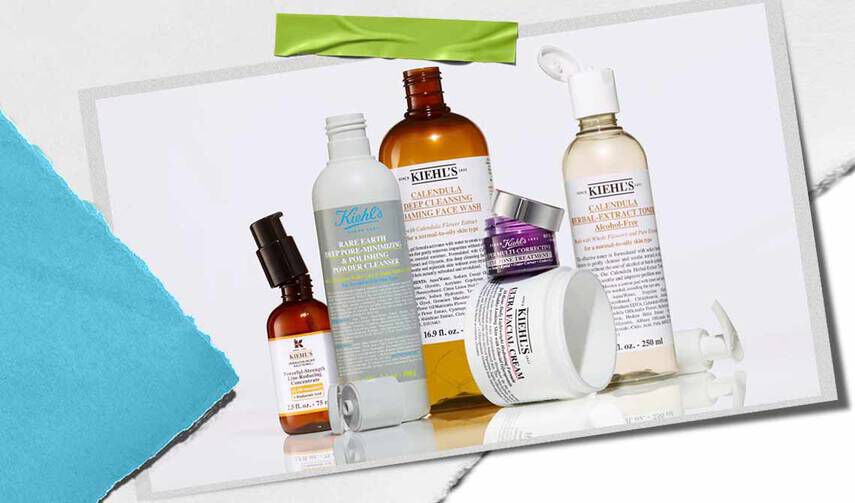 En samling af Kiehl's hudplejeprodukter, herunder serummer, renseprodukter og fugtighedscremer, udstillet på en tekstureret baggrund.