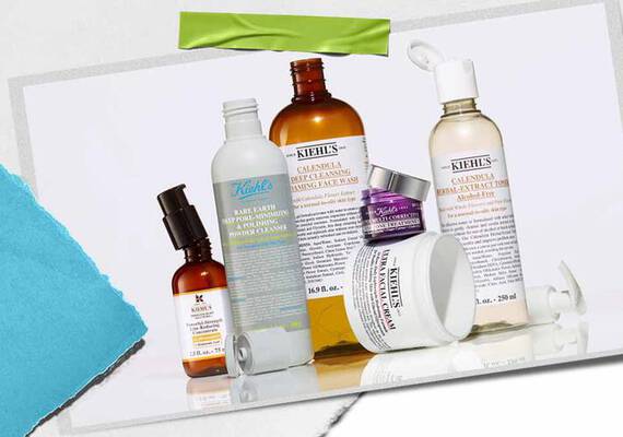 En samling af Kiehl's hudplejeprodukter, herunder serummer, renseprodukter og fugtighedscremer, udstillet på en tekstureret baggrund.