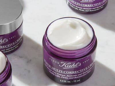 A jar of Kiehl's Multi-Corrective Cream with a creamy texture, set against a marble background, showcasing skincare product design.