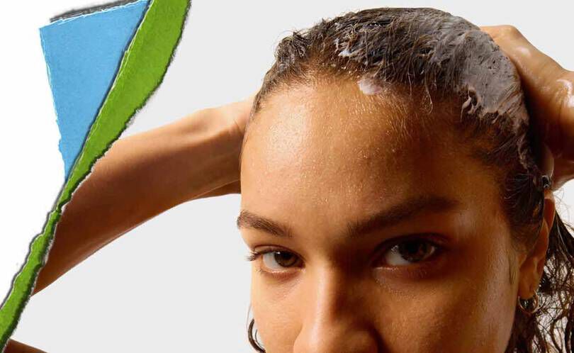 En person med vådt hår påfører et hårprodukt med en farverig, afrevet papirsektion i baggrunden.