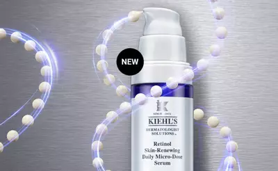A bottle of Kiehl's Retinol Skin-Renewing Daily Micro-Dose Serum on a metallic background, surrounded by a stylized representation of molecules, with a "NEW" label prominently displayed.