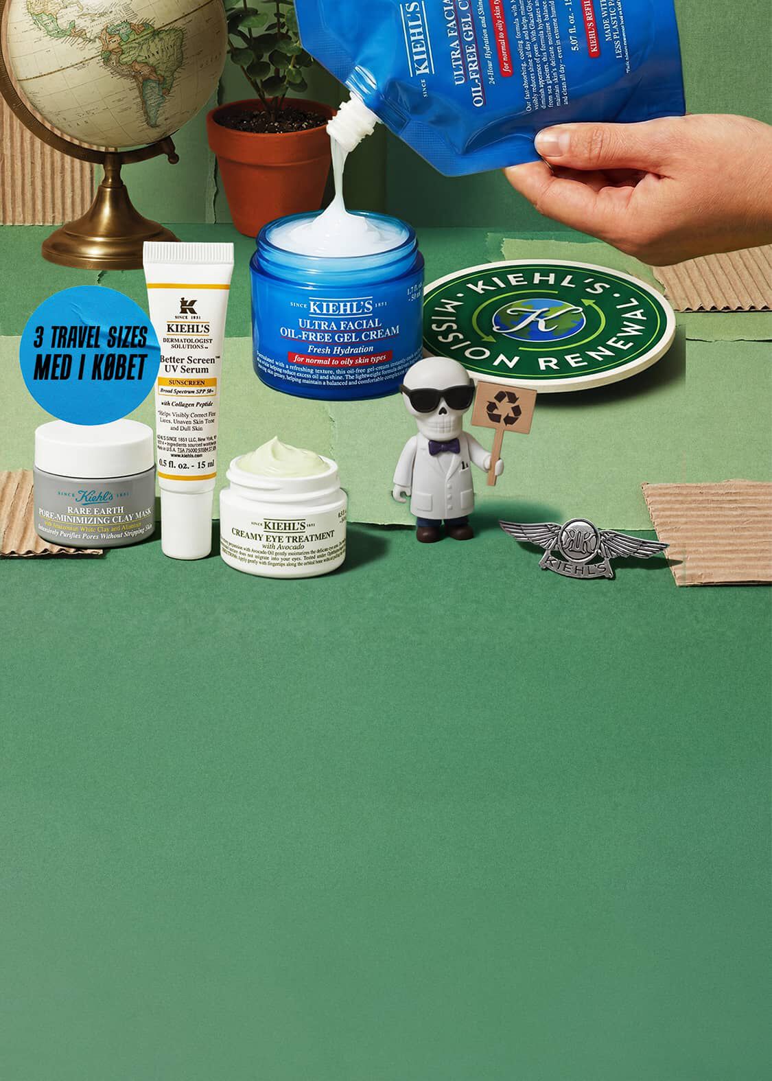 Haender, der haelder Kiehl's Ultra Facial Oil-Free Gel Cream med andre Kiehl's hudplejeprodukter, en globus, en plante og en lille figur på grøn baggrund.