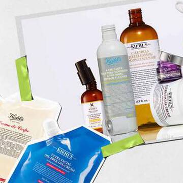 En samling af Kiehl's hudplejeprodukter, herunder lotion og serum, arrangeret kunstnerisk med levende emballage og synlige etiketter.