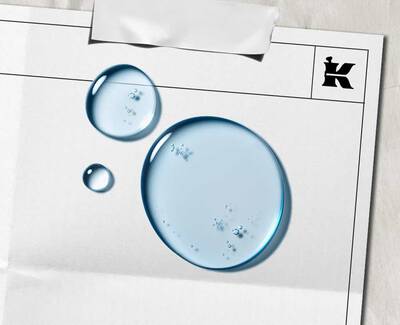 To vanddråber på et blankt stykke papir med et sort "K"-logo og et stykke tape øverst.