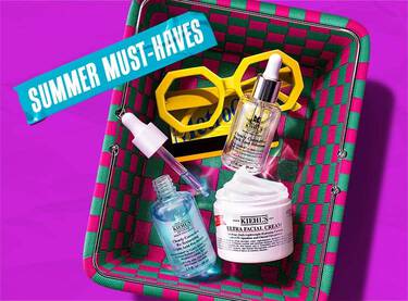Et lilla banner med en grøn og pink flettet kurv fyldt med Kiehl's hudplejeprodukter og gule solbriller, med blå tape hvor der står 'SUMMER MUST-HAVES'.