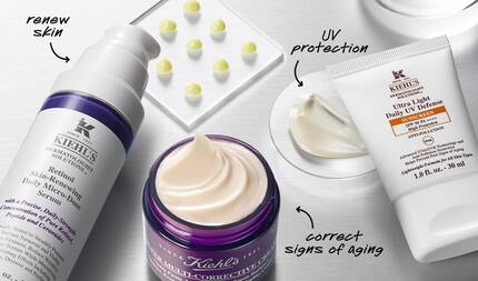 A flat lay of skincare products featuring a serum, a cream, and a sunscreen, labeled with their benefits: "renew skin," "UV protection," and "correct signs of aging."