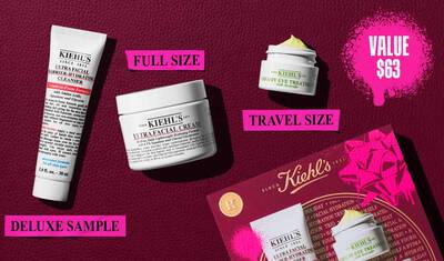 En grafik, sat mod en mørkerød tekstureret baggrund, viser tre produkter og en gaveaeske. En hvid tube med "KIEHL’S ULTRA FACIAL BARRIER-HYDRATING CLEANSER" er maerket "DELUXE SAMPLE" med lys pink skrift. En hvid krukke med "KIEHL’S ULTRA FACIAL CREAM" er maerket "FULL SIZE" med lys pink skrift. En lille hvid krukke med "KIEHL’S CREAMY EYE TREATMENT WITH AVOCADO" med synlig lysegul creme er maerket "TRAVEL SIZE" med lys pink skrift. I nederste højre hjørne er en rød Kiehl’s gaveaeske, der viser de samme tre produkter, synlig, dekoreret med lyse pink grafiske malingspletter og et sløjfe design. I øverste højre hjørne indeholder en lys pink malingsplet teksten "VALUE $63."