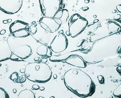 Close-up image of various clear water bubbles floating in a light background, creating a sense of movement and fluidity.