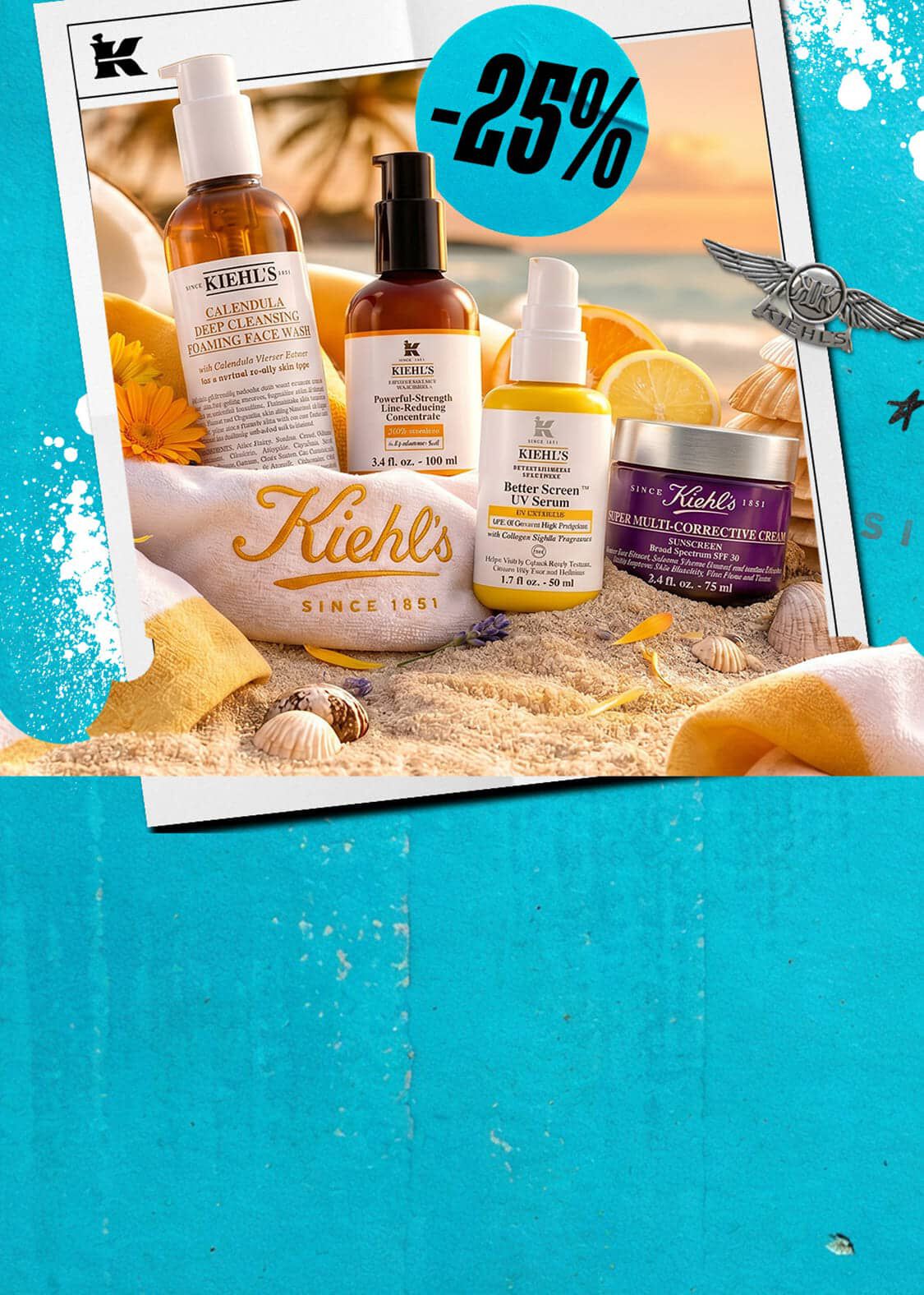 Kiehl's hudplejeprodukter, inklusive ansigtsvask, serum og creme, sat op mod en smuk solnedgang på stranden.