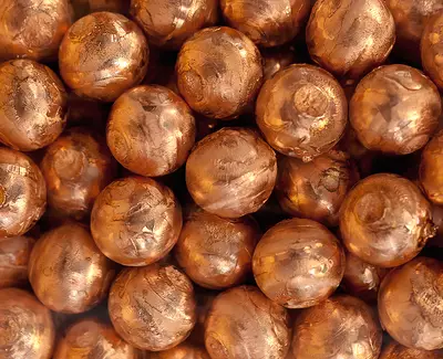 Close-up of a dense cluster of brown, metallic spheres with a shiny surface.