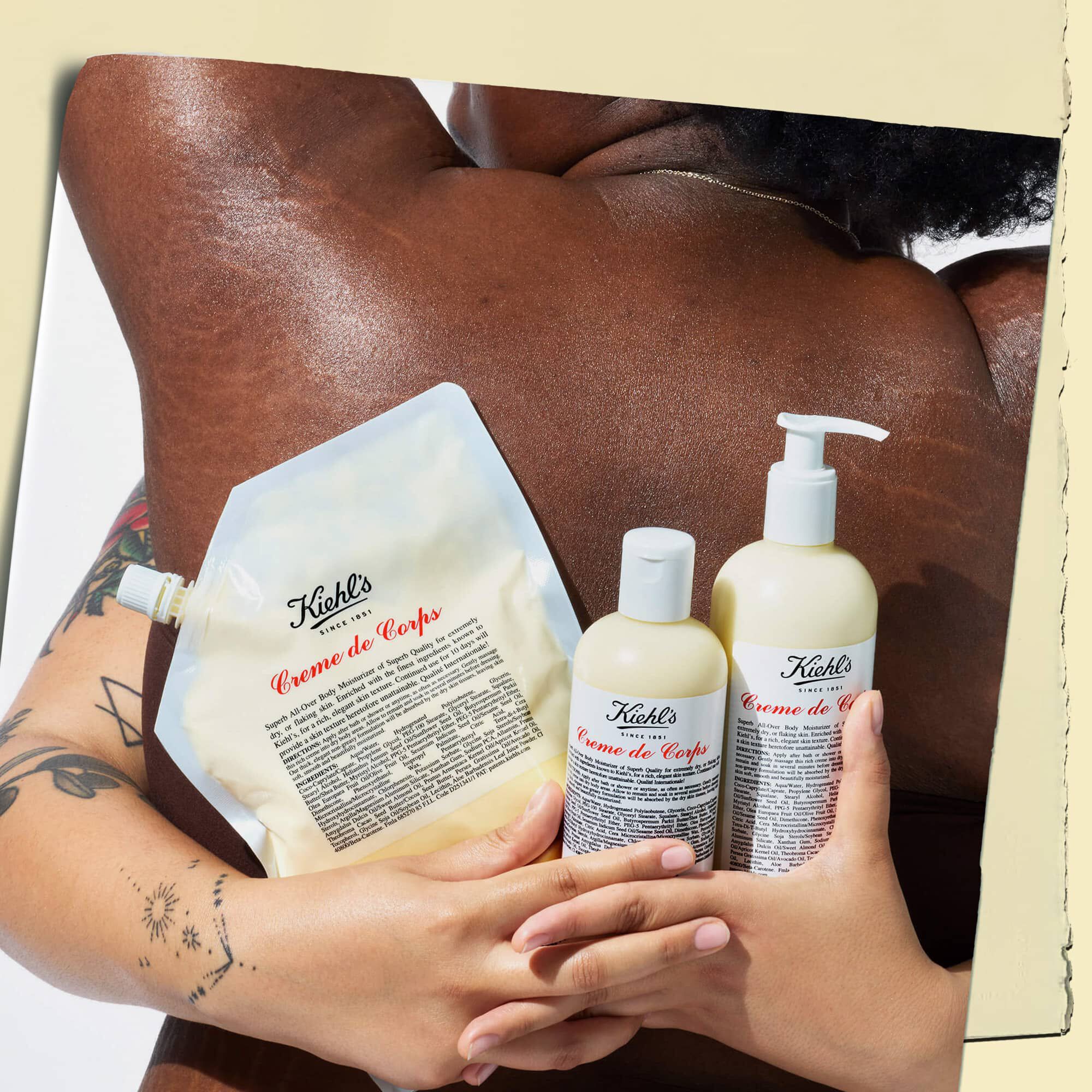 To modeller, der omfavner hinanden og holder tre flasker Creme de Corps i forskellige størrelser