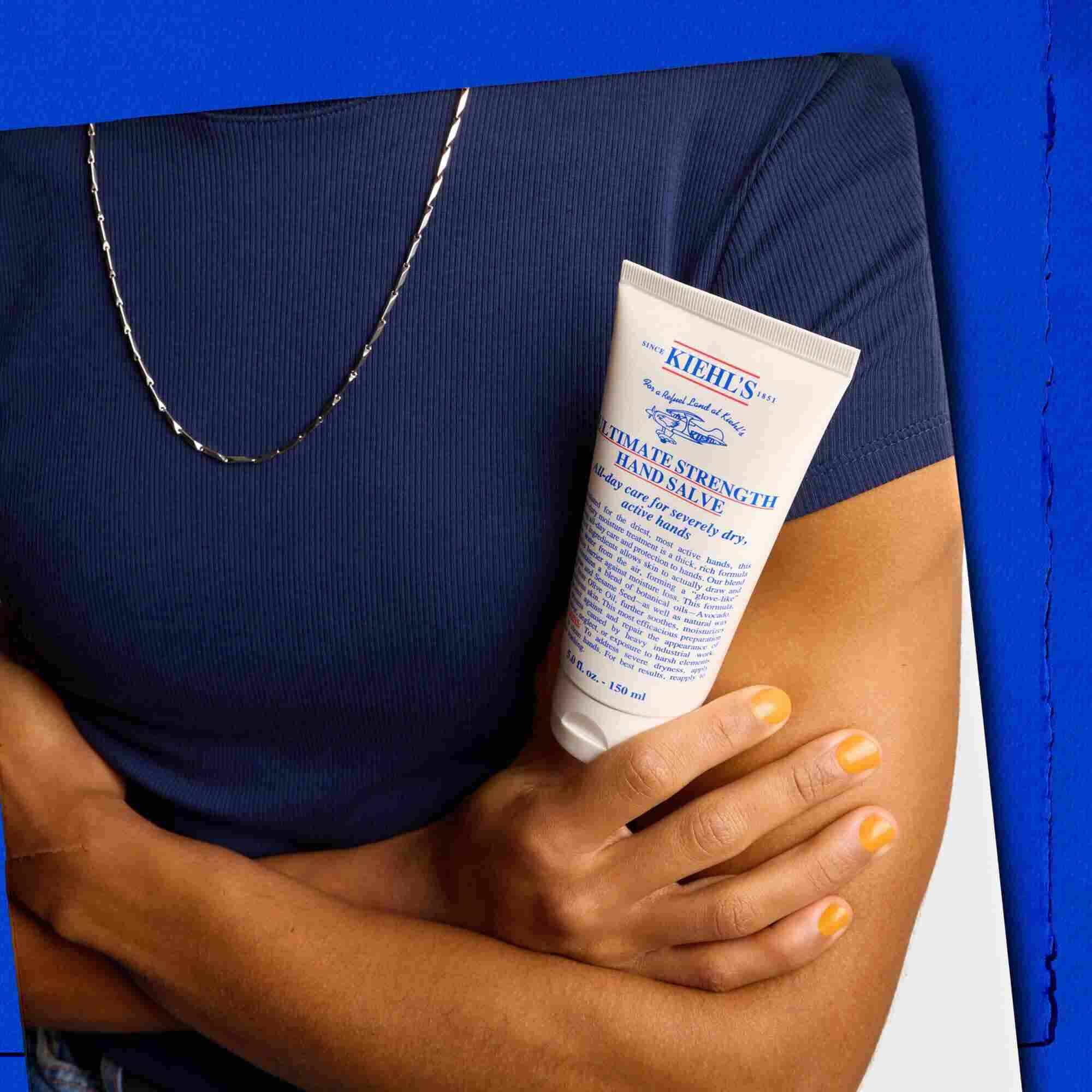 Model holder en tube med Kiehl's Ultimate Strength Hand Salve