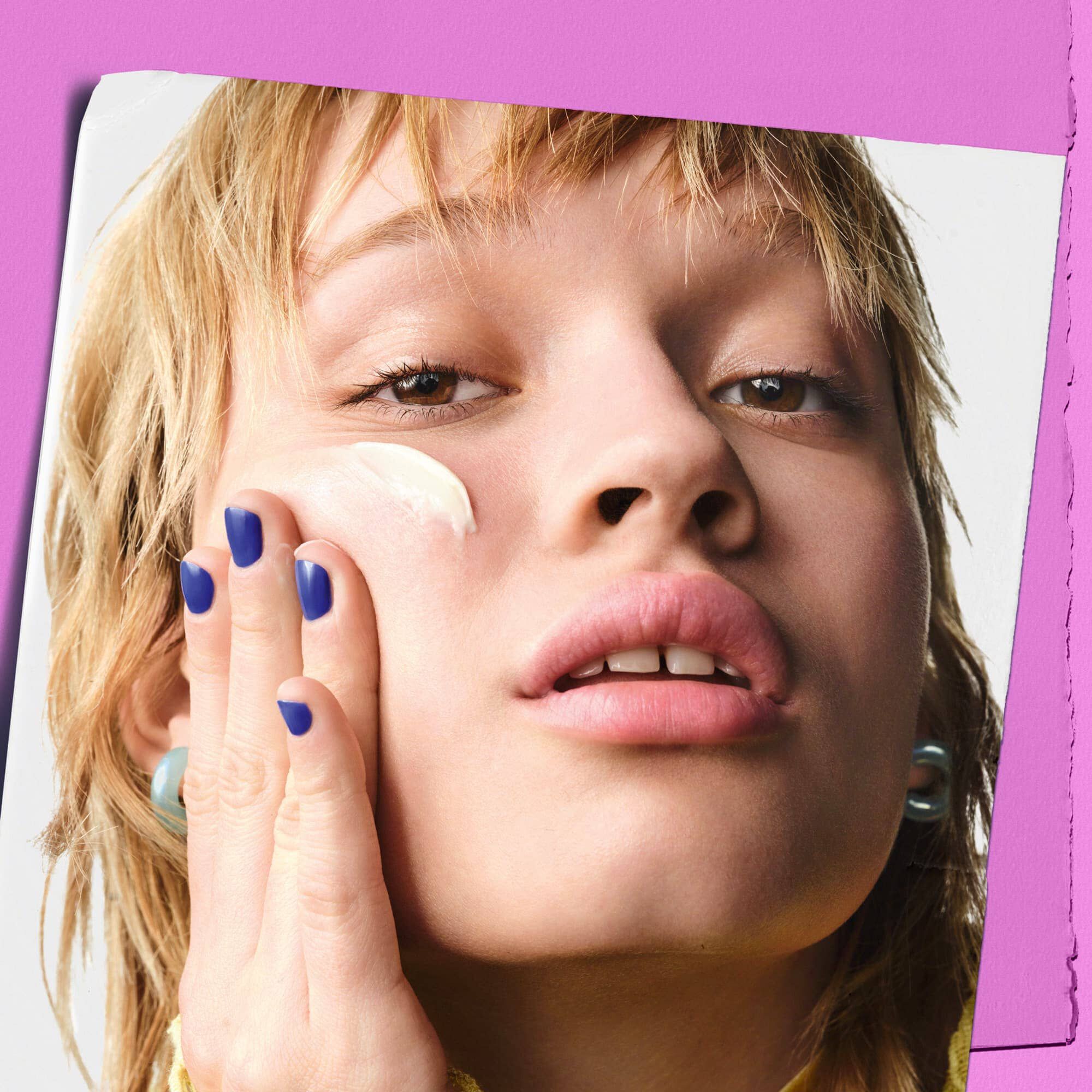 Model påfører Kiehl's Super Multi-Corrective Cream på kinden