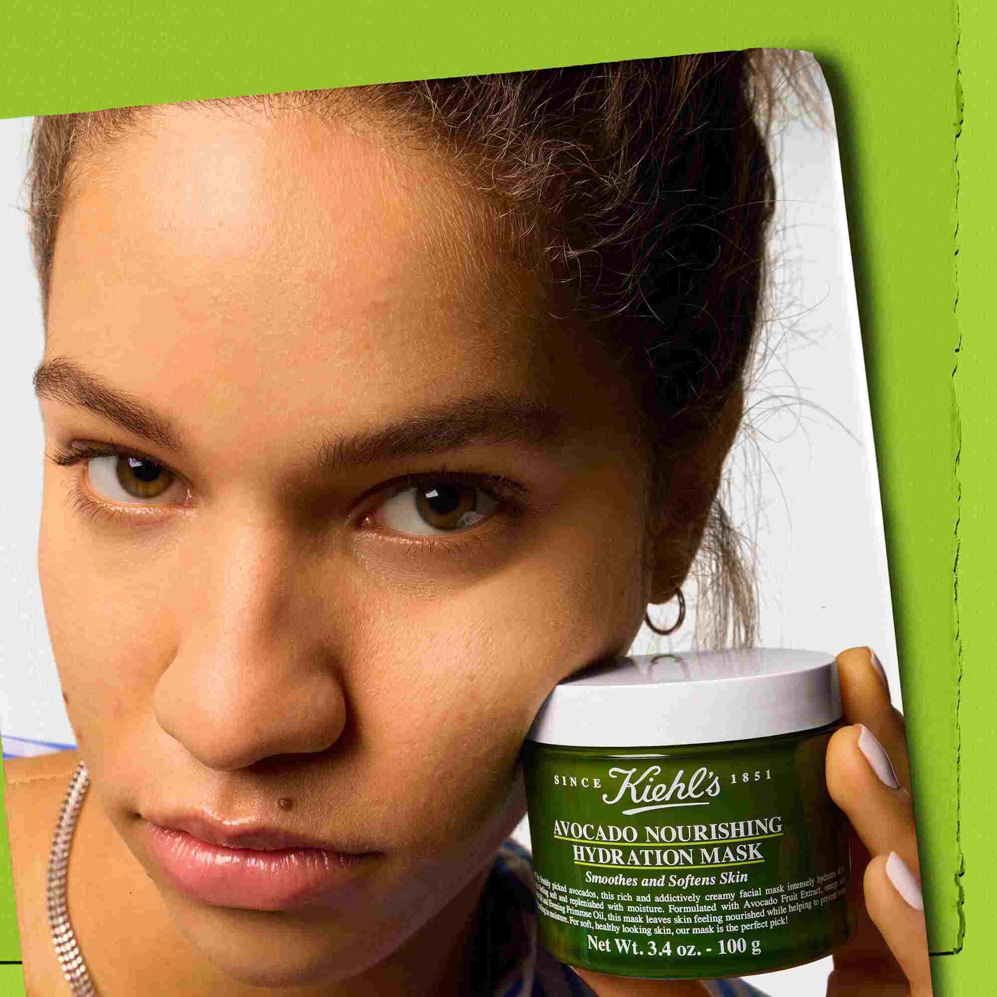 Model holder en krukke med Kiehl's Avocado Nourishing Hydration Mask – udglatter og blødgør huden