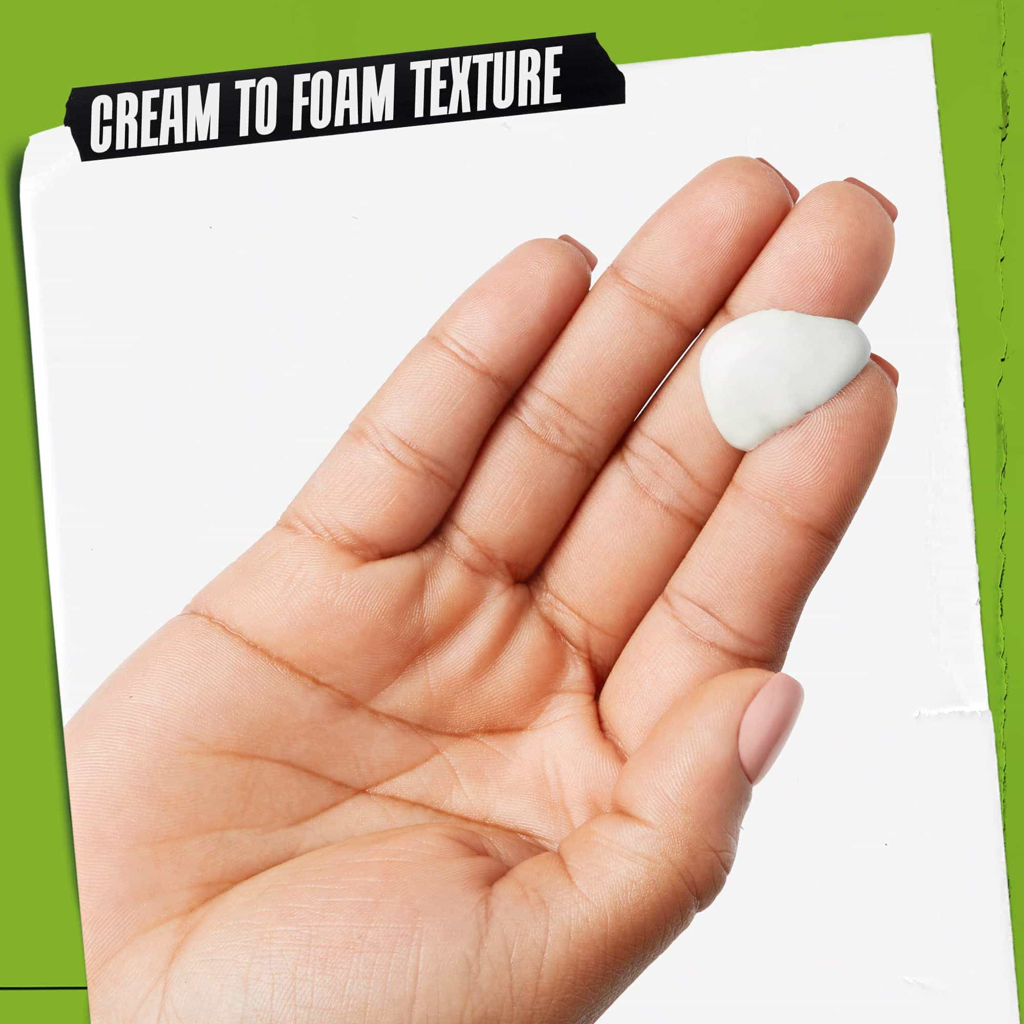 En hånd med Rare Earth Deep Pore Daily Cleanser på. Teksten fremhaever "Creme-til-skum konsistens".
