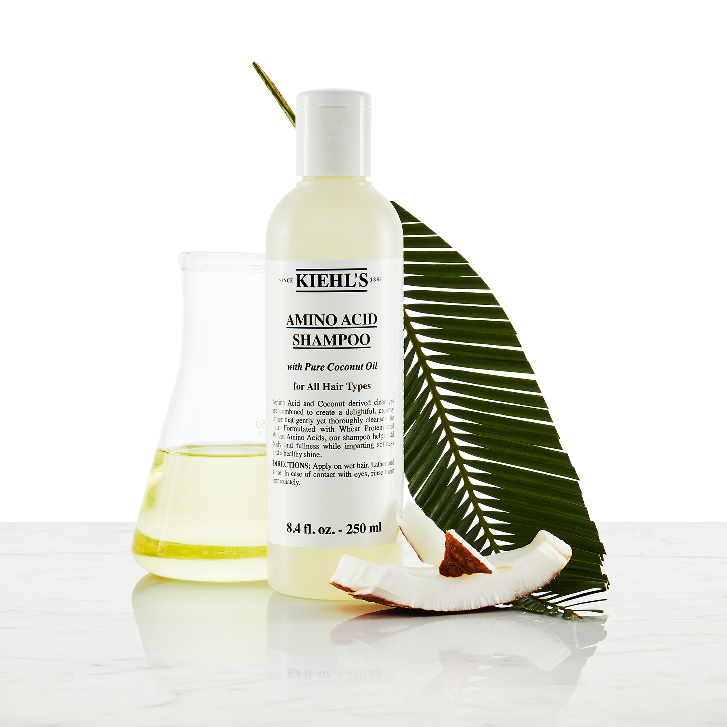 Model med overskaeg og en flaske Kiehl's Amino Acid Shampoo