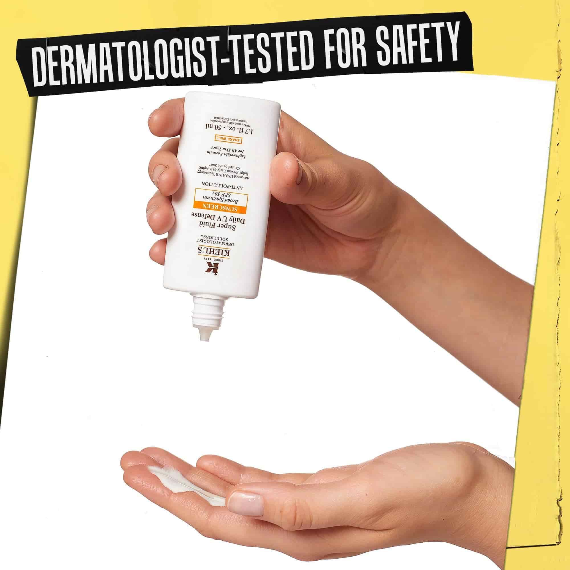 Hånd, hvor Ultra-Light Daily UV Defense doseres på, maerket "Dermatologisk testet for sikkerhed".